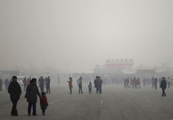 посетители олимпийского парка в Пекине среди густого тумана