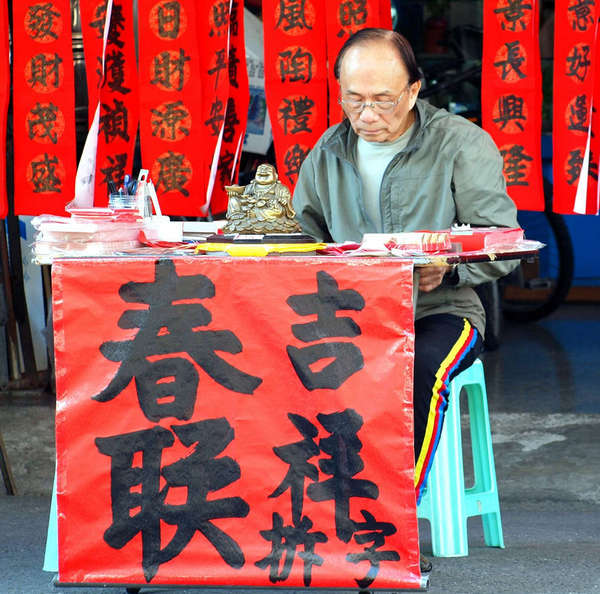 каллиграф подписывает традиционные новогодние открытки на уличном рынке (Тайвань, 2014 г.)