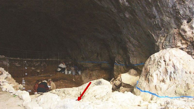 Мезмайская пещера. Красной стрелкой обозначен участок, на котором был обнаружен скелет новорожденного неандертальца.
