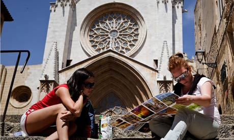 российские туристы изучают карту Таррагоны, Испания